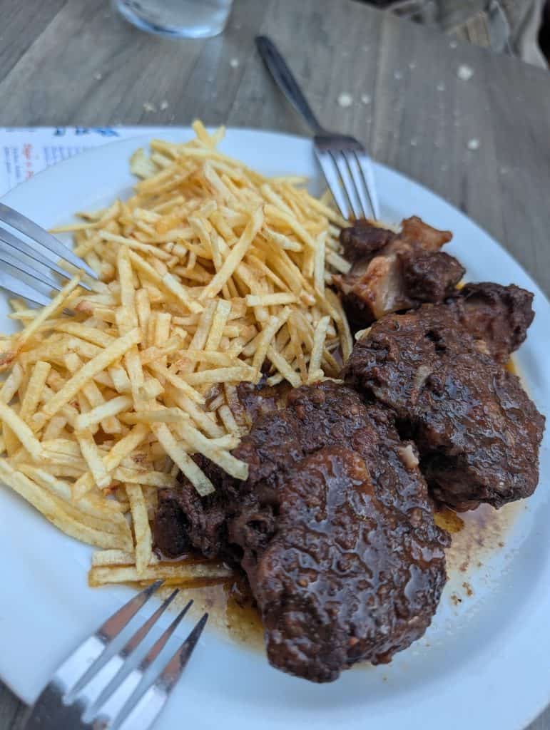 Plate of rabo de toro, Spanish braised oxtail stew, served at Cervecería El Hidalgo in Alcalá de Henares